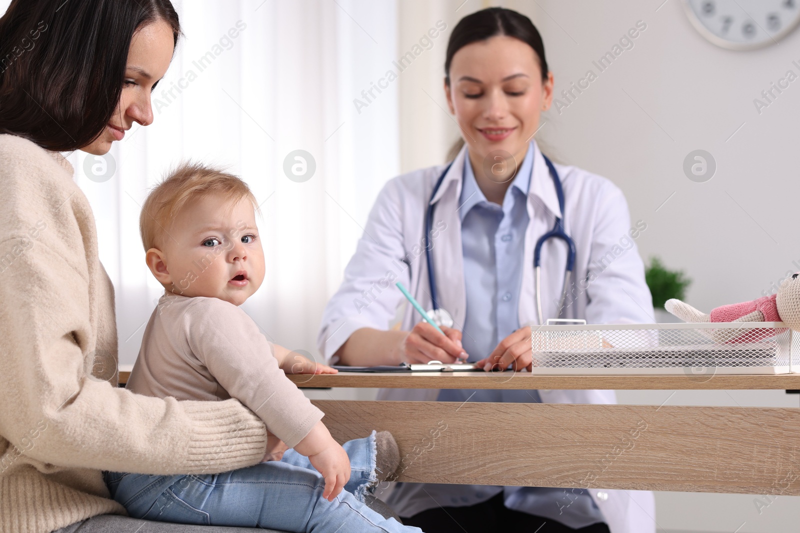 Mother and her cute baby having appointment with pediatrician in clinic, selective focus Photo of Mother and her cute baby having appointment with pediatrician in clinic, selective focus