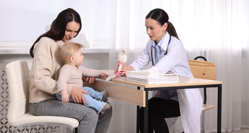 Photo of Mother and her cute baby having appointment with pediatrician in clinic
