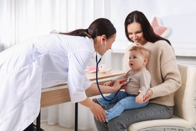 Photo of Pediatrician examining baby with stethoscope in clinic