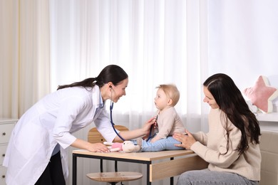 Photo of Pediatrician examining baby with stethoscope in clinic