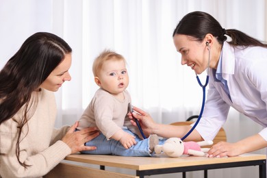 Photo of Pediatrician examining baby with stethoscope in clinic