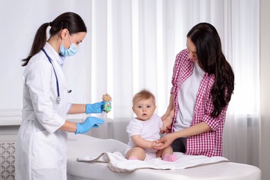 Photo of Mother and her cute baby having appointment with pediatrician in clinic