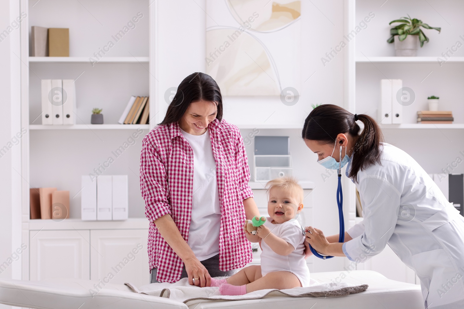 Pediatrician examining baby with stethoscope in clinic Photo of Pediatrician examining baby with stethoscope in clinic