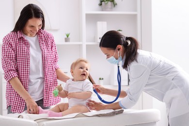 Photo of Pediatrician examining baby with stethoscope in clinic