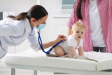 Photo of Pediatrician examining baby with stethoscope in clinic