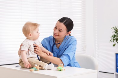 Photo of Pediatrician examining baby with stethoscope in clinic