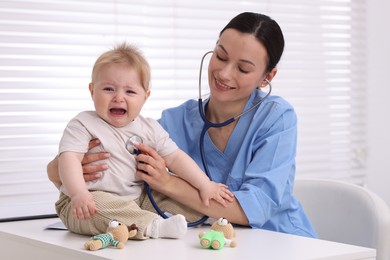 Photo of Pediatrician examining baby with stethoscope in clinic