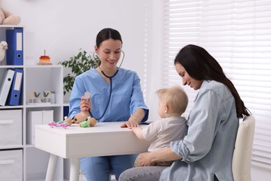 Photo of Mother and her cute baby having appointment with pediatrician in clinic