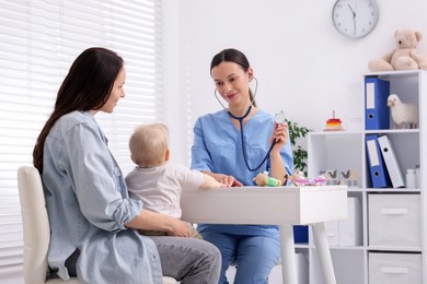 Photo of Mother and her cute baby having appointment with pediatrician in clinic