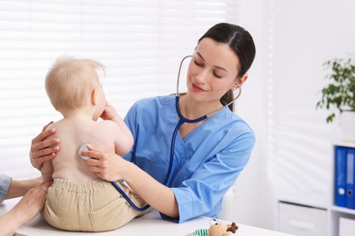 Photo of Pediatrician examining baby with stethoscope in clinic