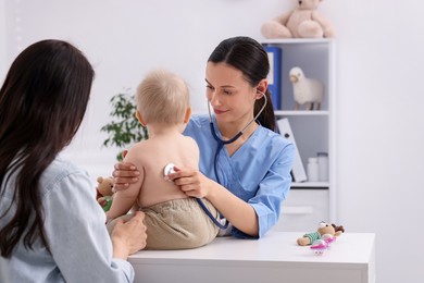 Photo of Pediatrician examining baby with stethoscope in clinic