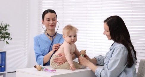 Photo of Pediatrician examining baby with stethoscope in clinic