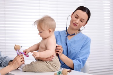 Photo of Pediatrician examining baby with stethoscope in clinic