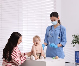 Photo of Mother and her cute baby having appointment with pediatrician in clinic. Doctor vaccinating child