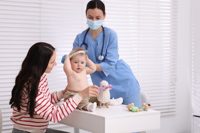 Photo of Pediatrician measuring little baby's head in clinic
