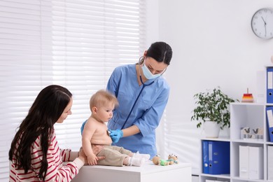 Photo of Pediatrician examining baby with stethoscope in clinic