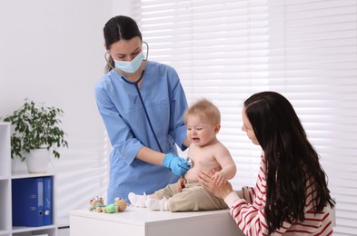 Photo of Pediatrician examining baby with stethoscope in clinic
