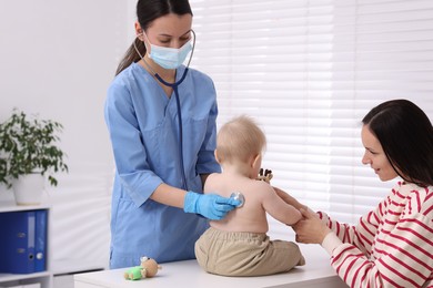 Photo of Pediatrician examining baby with stethoscope in clinic