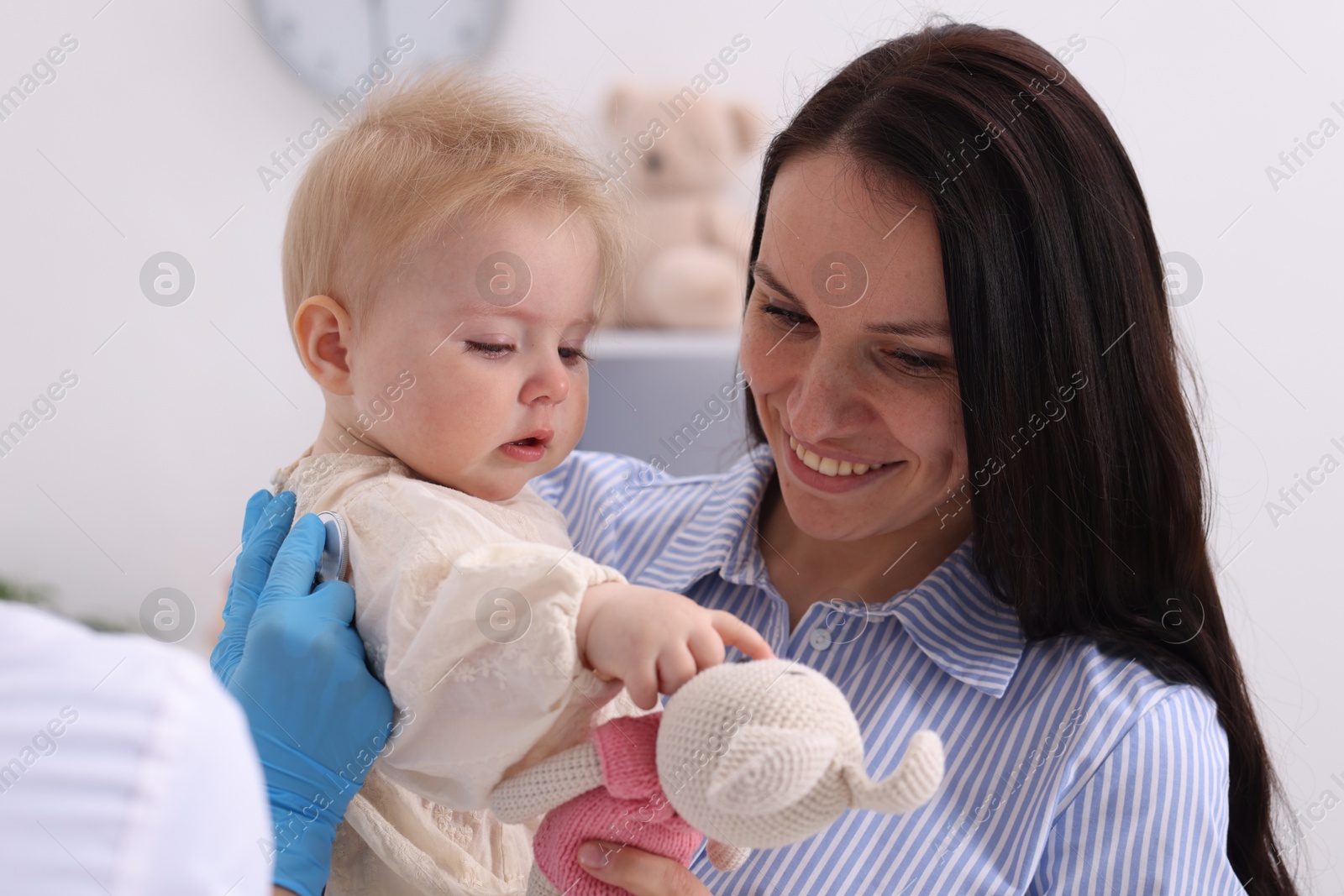 Pediatrician examining baby with stethoscope in clinic, closeup Photo of Pediatrician examining baby with stethoscope in clinic, closeup