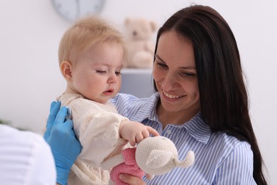 Photo of Pediatrician examining baby with stethoscope in clinic, closeup