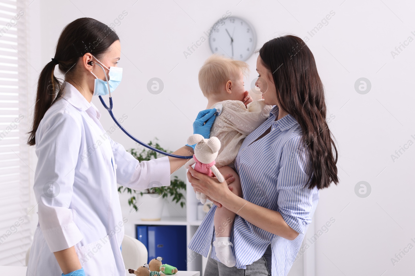 Pediatrician examining baby with stethoscope in clinic Photo of Pediatrician examining baby with stethoscope in clinic