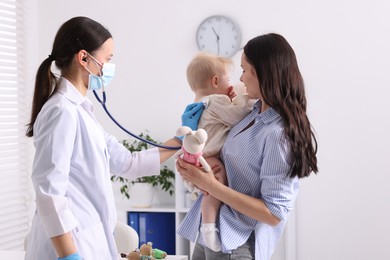 Photo of Pediatrician examining baby with stethoscope in clinic