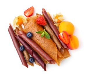 Photo of Delicious fruit leather rolls, mint and berries isolated on white, top view