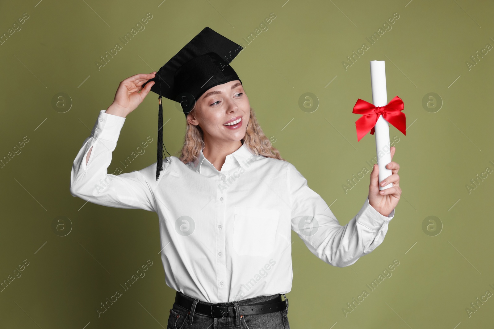 Happy student with diploma after graduation on green background Photo of Happy student with diploma after graduation on green background