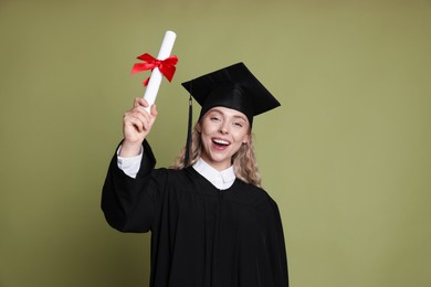 Photo of Happy student with diploma after graduation on green background