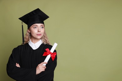 Photo of Student with diploma after graduation on green background. Space for text