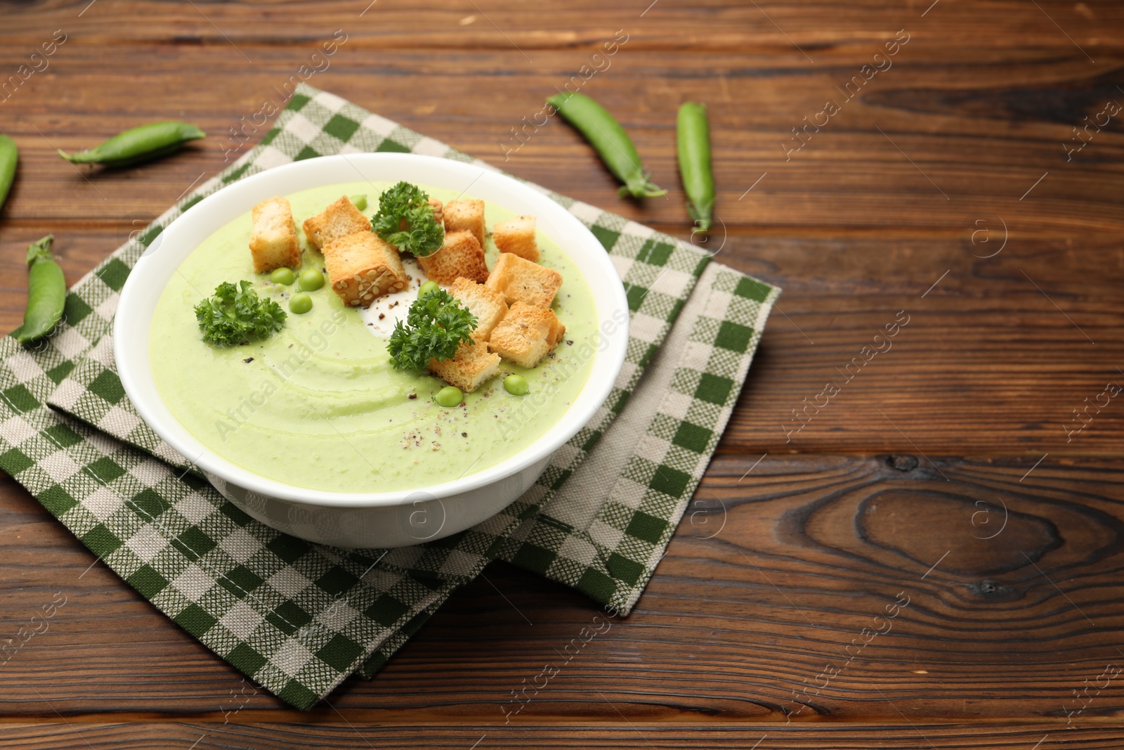 Tasty pea cream soup with croutons and broccoli served on wooden table. Space for text Photo of Tasty pea cream soup with croutons and broccoli served on wooden table. Space for text