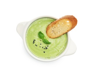 Photo of Tasty pea cream soup with basil and crouton isolated on white, top view