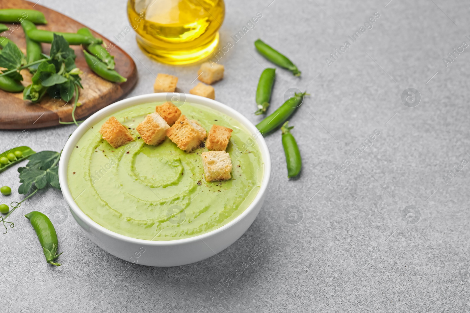 Tasty pea cream soup with croutons served on grey table. Space for text Photo of Tasty pea cream soup with croutons served on grey table. Space for text