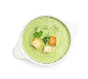 Photo of Tasty pea cream soup with croutons and microgreens isolated on white, top view