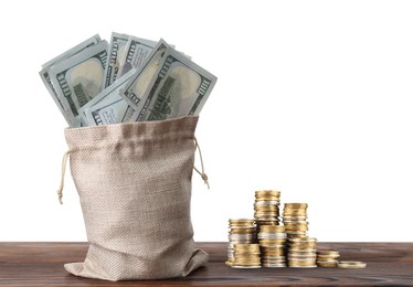 Image of Wealth. Burlap bag full of dollar bills and stacked coins on wooden table against white background