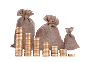 Image of Wealth. Burlap bags and stacks of coins from bigger to smaller isolated on white