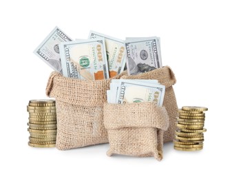 Image of Wealth. Burlap bags full of dollar bills and stacked coins isolated on white