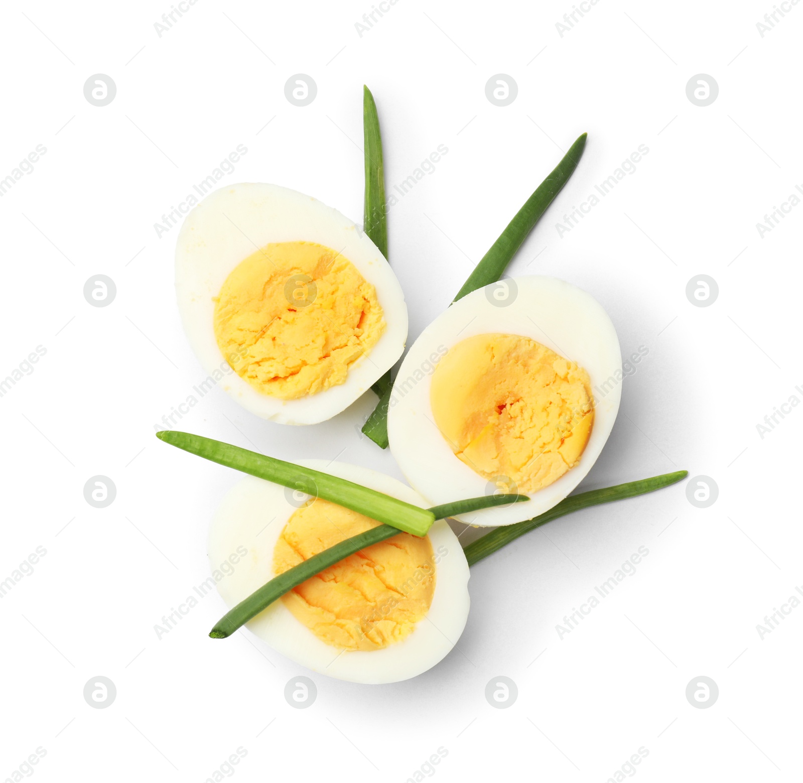 Photo of Halves of hard boiled eggs with green onions isolated on white, top view