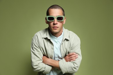 Photo of Fashionable portrait of handsome man in stylish outfit on green background
