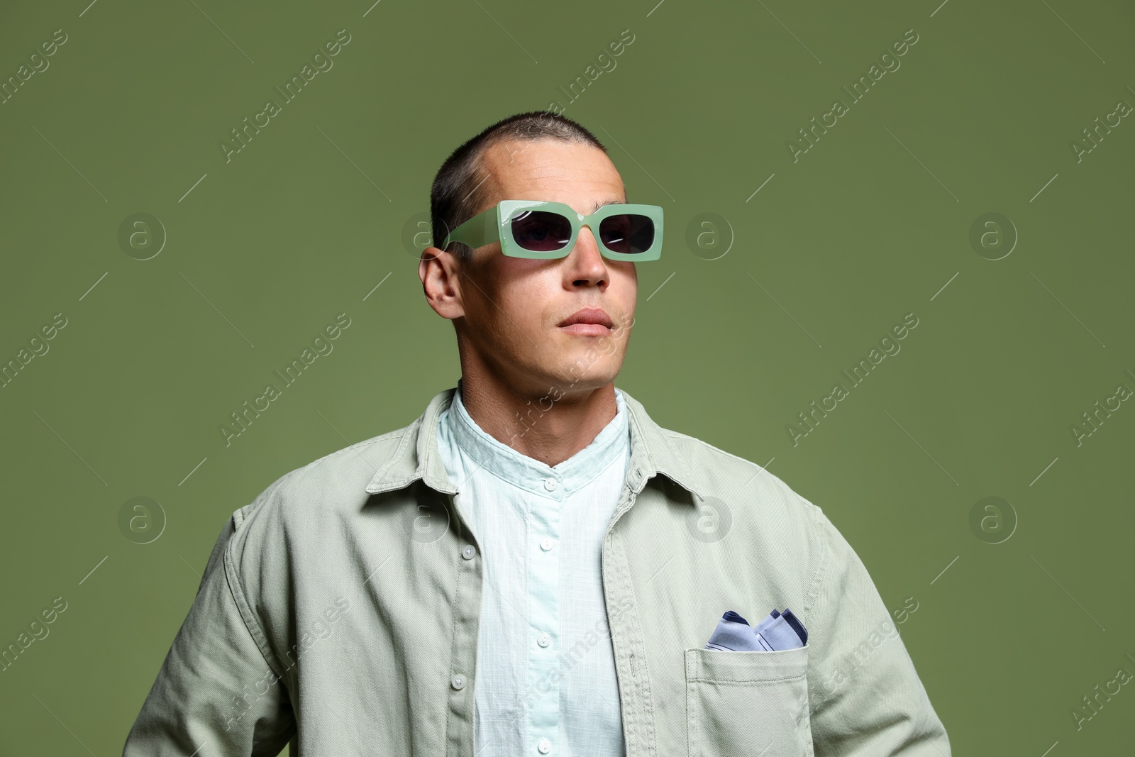 Fashionable portrait of handsome man in stylish outfit on green background Photo of Fashionable portrait of handsome man in stylish outfit on green background