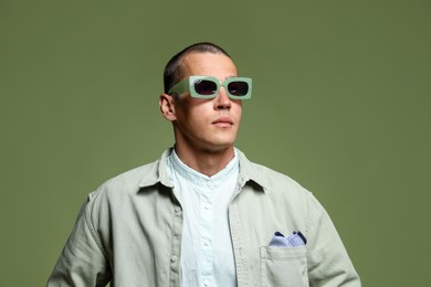 Photo of Fashionable portrait of handsome man in stylish outfit on green background