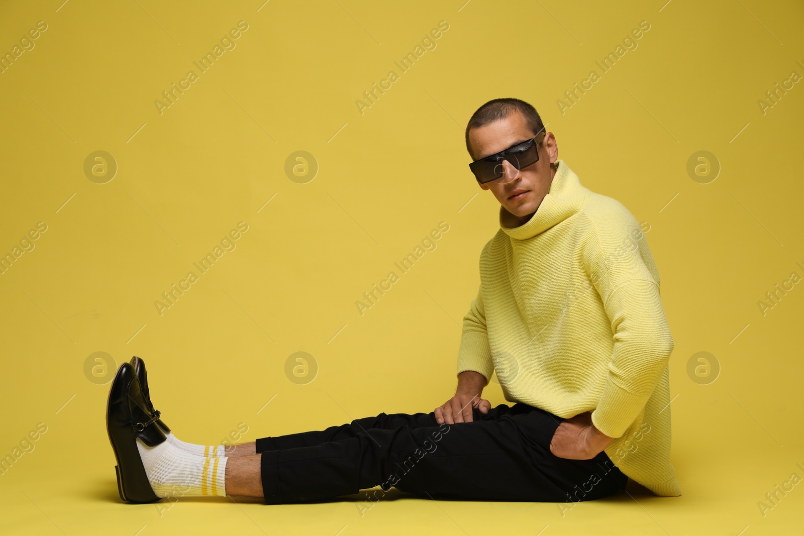 Fashionable portrait of handsome man in stylish outfit on yellow background Photo of Fashionable portrait of handsome man in stylish outfit on yellow background