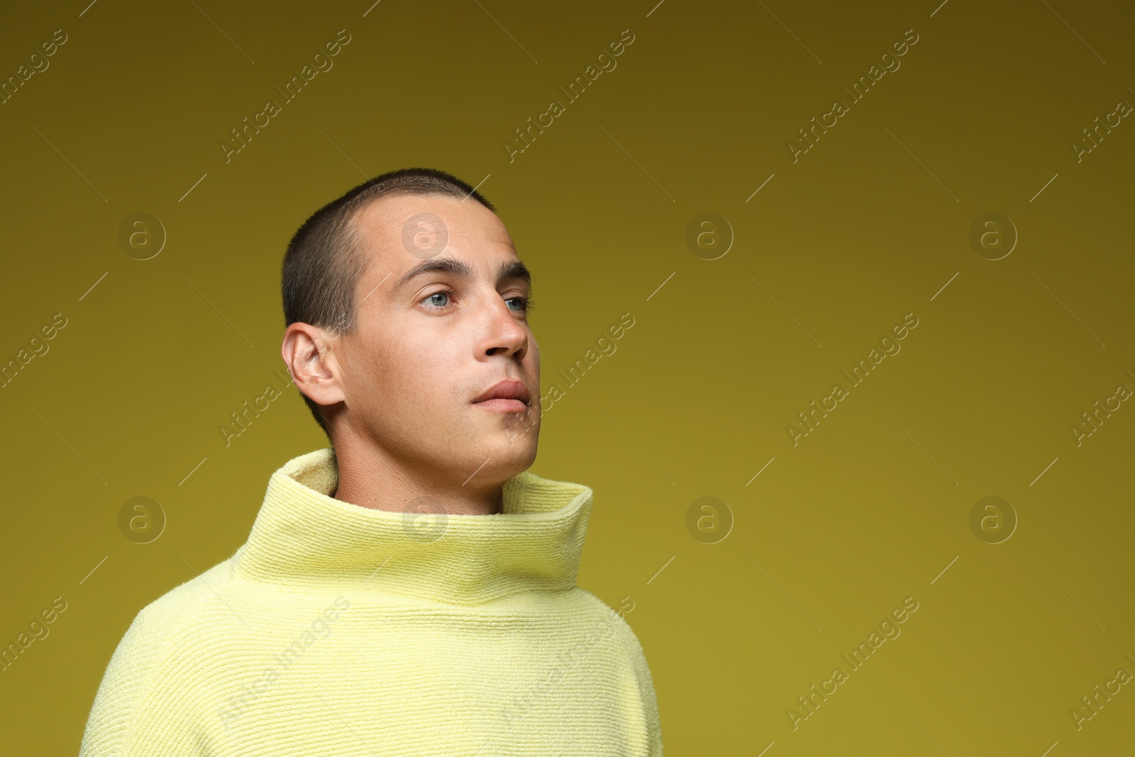 Fashionable portrait of handsome man in stylish outfit on olive background, space for text Photo of Fashionable portrait of handsome man in stylish outfit on olive background, space for text