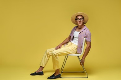 Photo of Fashionable portrait of handsome man in stylish outfit on yellow background