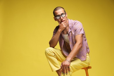 Photo of Fashionable portrait of handsome man in stylish outfit on color background, space for text