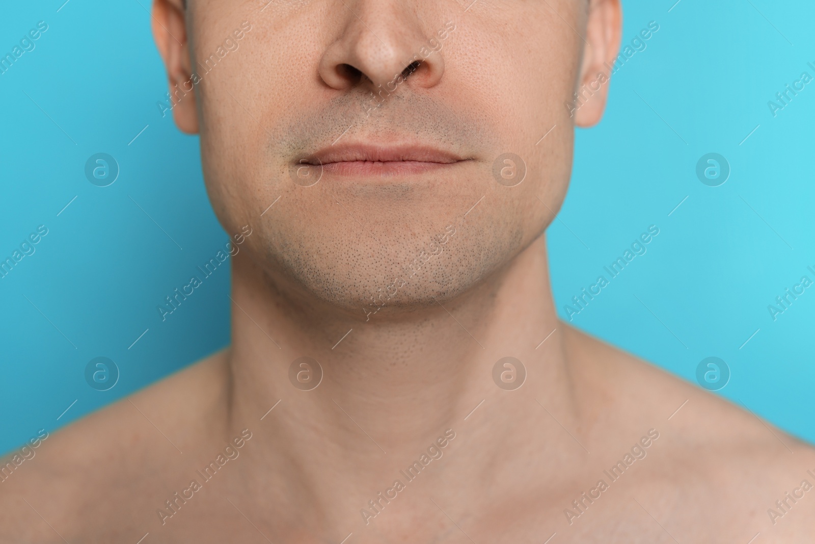 Man after shaving on light blue background, closeup Photo of Man after shaving on light blue background, closeup