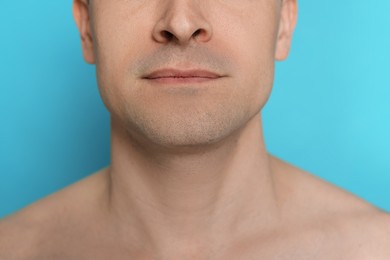 Photo of Man after shaving on light blue background, closeup