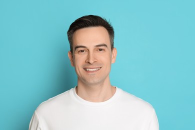 Photo of Smiling man after shaving on light blue background