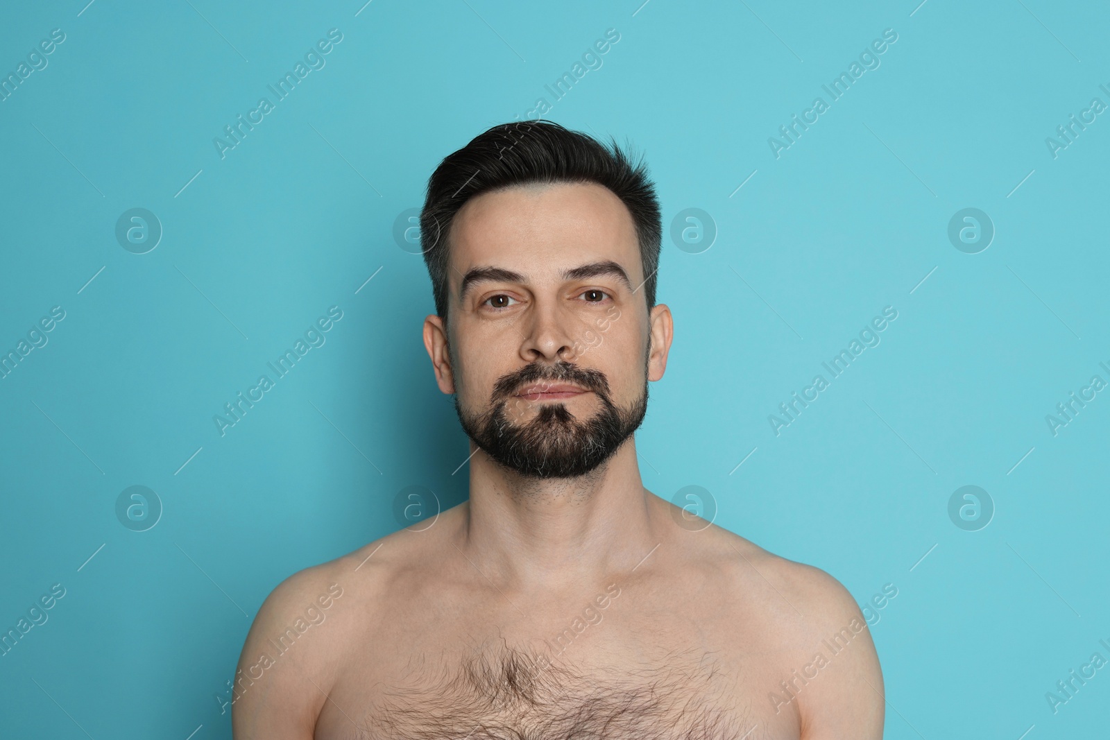 Handsome man before shaving on light blue background Photo of Handsome man before shaving on light blue background