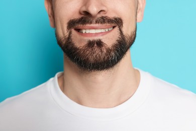 Photo of Smiling man before shaving on light blue background, closeup